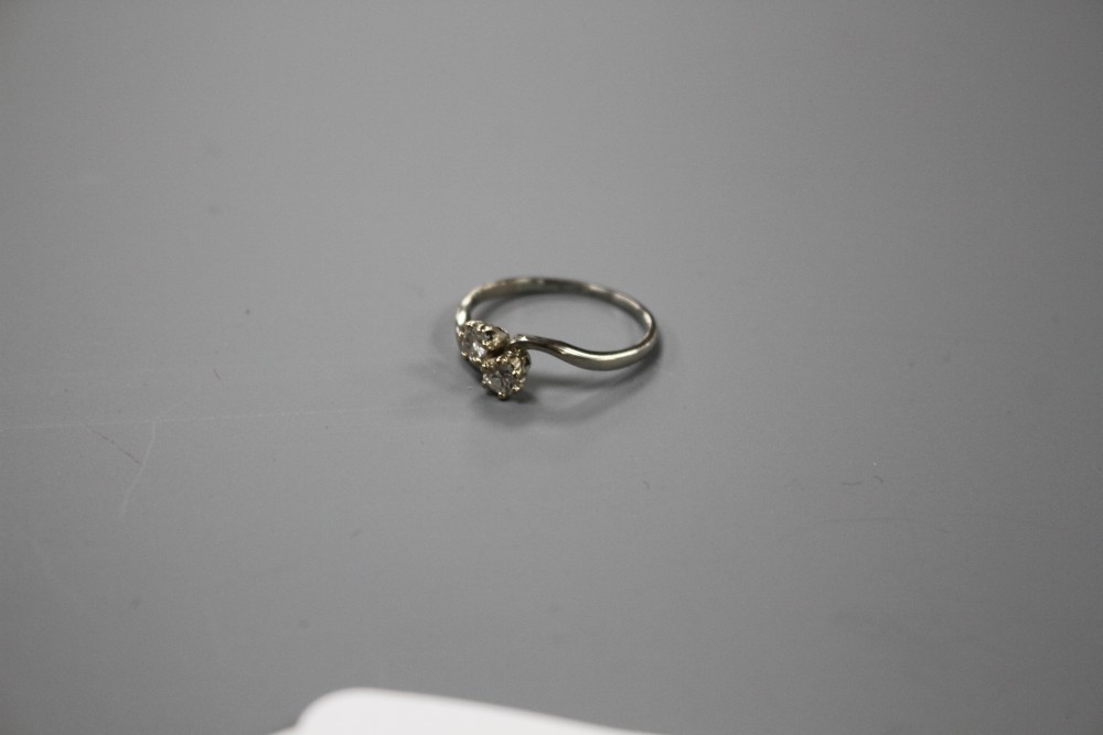 An 18ct and Plat, two stone diamond crossover ring, size P/Q, gross weight 2.5 grams.